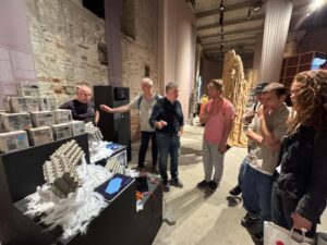  Public engagement at the Venice Biennale: visitors gather around the Material Bank exhibit featuring 3D printed graphene concrete prototypes.
